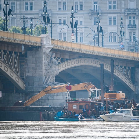 Rescue teams in Budapest work to recover bodies...