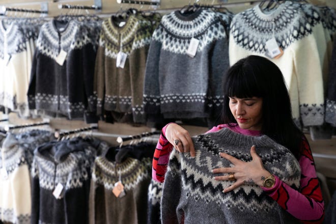 Sales assistant Nuria Medina Marin folds a 'lopi' sweater in the Nordic store in Reykjavik.