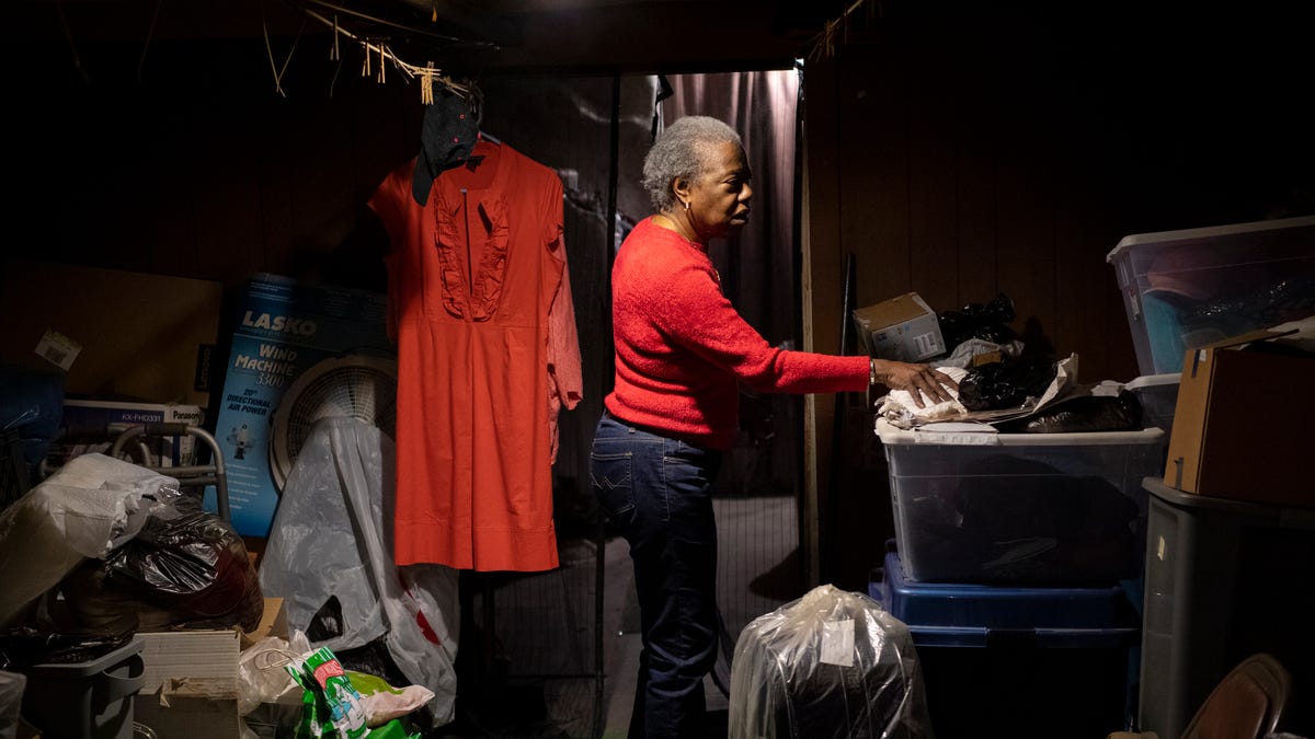 Patricia Blair looks over the items left in the basement as she prepares to vacate her second-generation home and move into an apartment. 