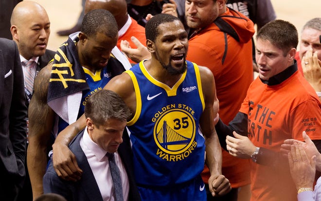 Golden State Warriors forward Kevin Durant leaves the court after suffering an Achilles injury during the first half Monday night.
