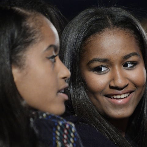 Malia and Sasha Obama attend the national...