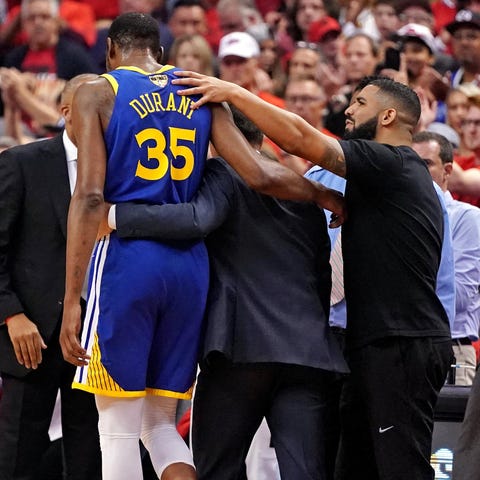 Drake comforts Kevin Durant after his injury.