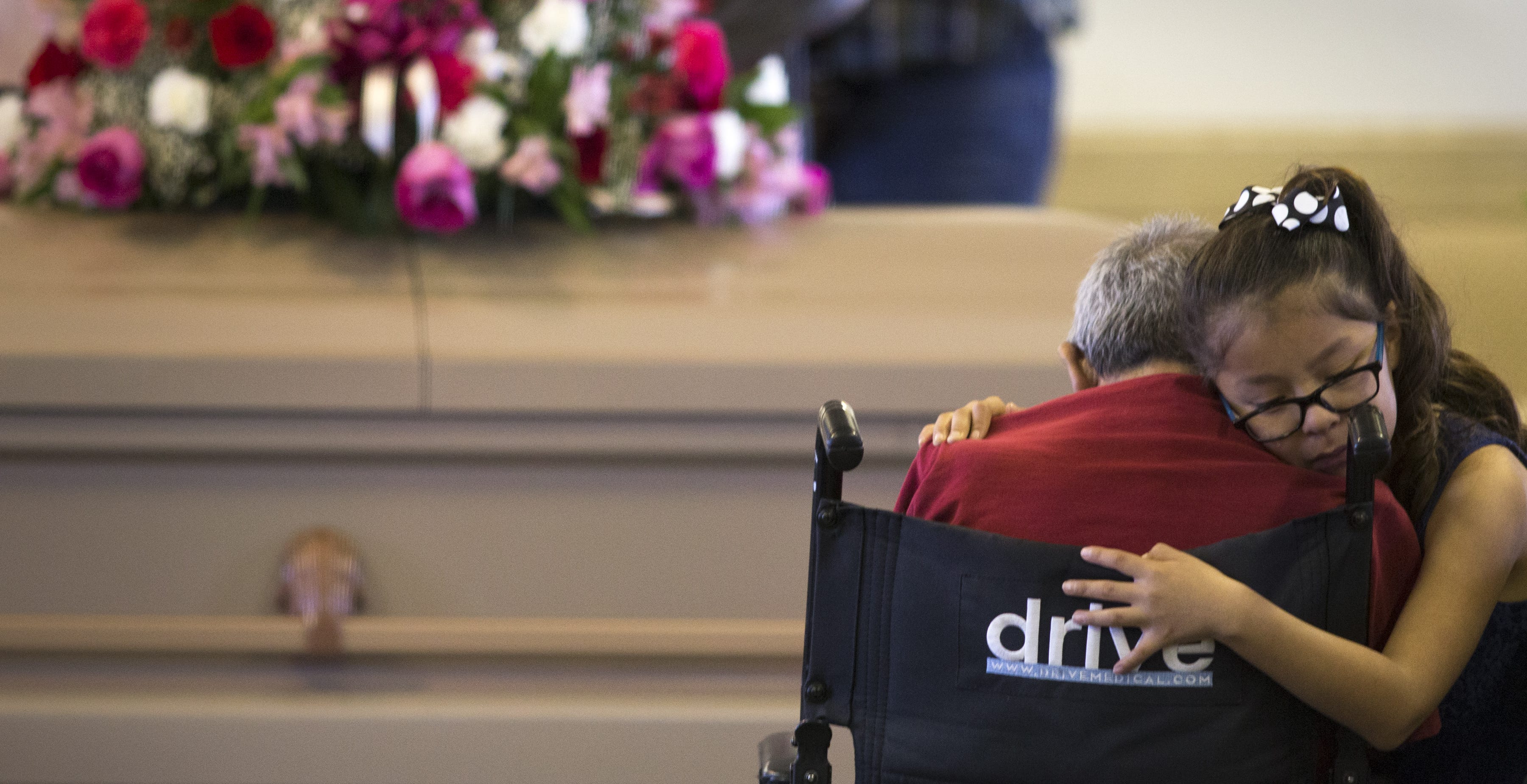 Tiffany Robbins, the daughter of Loreal Tsingine, hugs her grandfather, Edward Barnell, during funeral services for Tsingine on April 5, 2016, at the Cedar Springs Nazarene Church in Cedar Springs, Arizona.