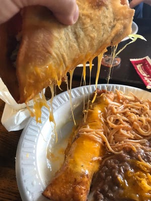 The cheese covered enchilada leaves residue on the deep-fried taco on a combo platter at Henry J's Taco House on June 11, 2019.