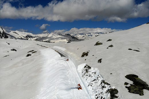 epa07645478 A picture taken with a drone shows a snow plough clears away snow on the cantonal road to the Nufenen Pass in Switzerland, 13 June 2019. Due to the danger of avalanches, the pass road will not be reopened until 19 June. EPA-EFE/SAMUEL GOLAY ORG XMIT: NUF07