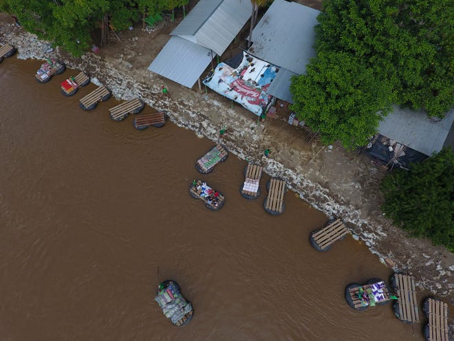 Inner tube and plank rafts ferry passengers and merchandise freely across the Suchiate River between Ciudad Hidalgo, Mexico, and Guatemala (not pictured), Thursday, June 13, 2019.