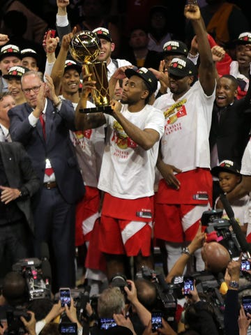 Raptors forward Kawhi Leonard lifts the Larry O'Brien Championship Trophy after beating the Warriors.