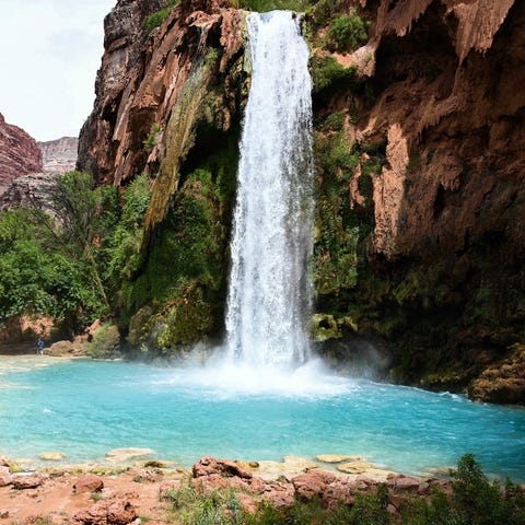 Havasu Falls is a striking blue-green waterfall...