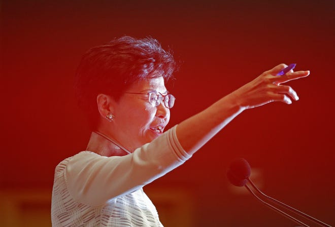 Hong Kong Chief Executive Carrie Lam gestures behind a red barrier tape during a press conference in Hong Kong Saturday.