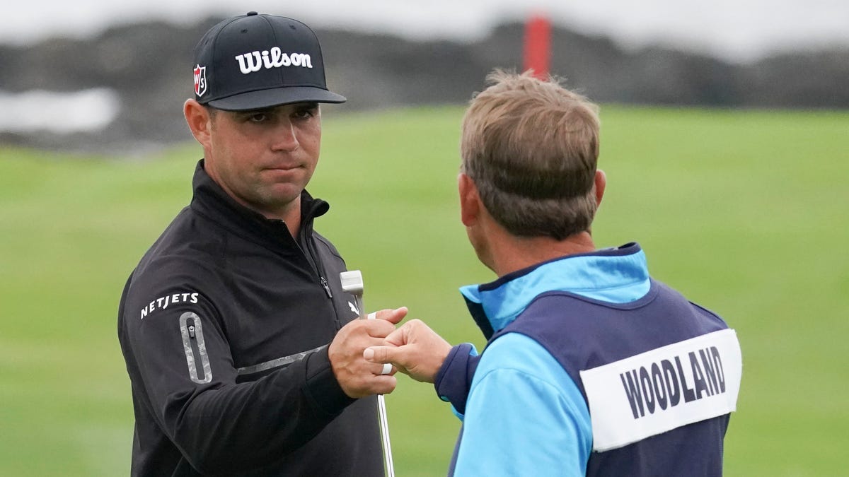 Gary Woodland, left, is congratulated by caddie Brennan Little after making a birdie on the ninth green.