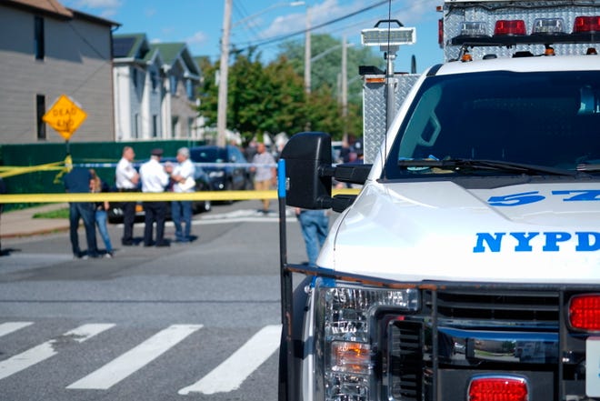 New York City Police officials gather along Wilcox Street behind the 121st Precinct station house following a report of a police officer shot in the Staten Island borough of New York, Friday, June 14, 2019. The officer