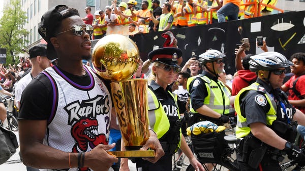 Kyle Lowry carries the Larry O'Brien Championship...