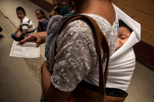 A woman holds a piece of paper confirming she voted during general elections as she leaves a polling station in Chinautla on the outskirts of Guatemala City, Sunday, June 16, 2019. Guatemalans are voting for their next president in elections plagued by widespread disillusion and distrust, and as thousands of their compatriots flee poverty and gang violence to seek a new life in the United States. (AP Photo/Oliver de Ros)