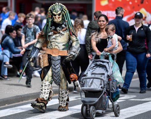 A cosplayer dressed as Predator walks at a cosplayer meeting in Bottrop, Germany, Saturday, June 15, 2019. (AP Photo/Martin Meissner)