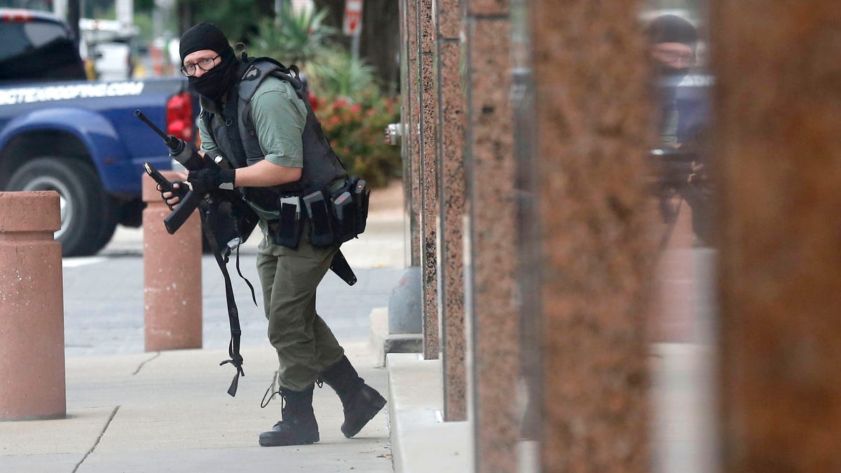 An armed shooter stands near the Earle Cabell Federal Building Monday, June 17, 2019, in downtown Dallas. The shooter was hit and injured in an exchange of gunfire with federal officers outside the courthouse.