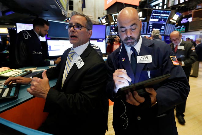 In this June 6, 2019, file photo specialist Anthony Rinaldi, left, and trader Fred DeMarco work on the floor of the New York Stock Exchange.