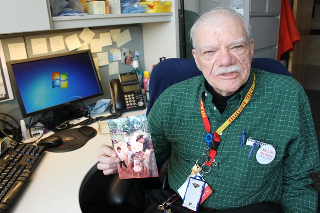 Bob Hall was one of the earliest patients to be interviewed for the My Life, My Story program at the William S. Middleton Memorial Veterans Hospital in Madison, Wisconsin in 2014. "I'd never experienced something like that in a hospital before," Hall said. Hall holds a photograph of himself playing with children in a village in Vietnam during his time as a Marine.