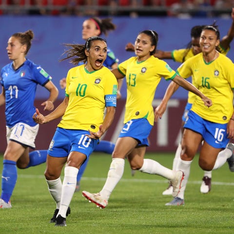 Marta celebrates with teammates after scoring...