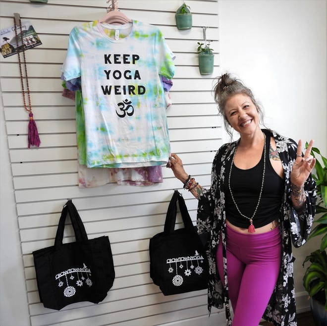 Cindy Kostecki of Crowtown Yoga shows off some items in the new boutique area of her yoga studio.