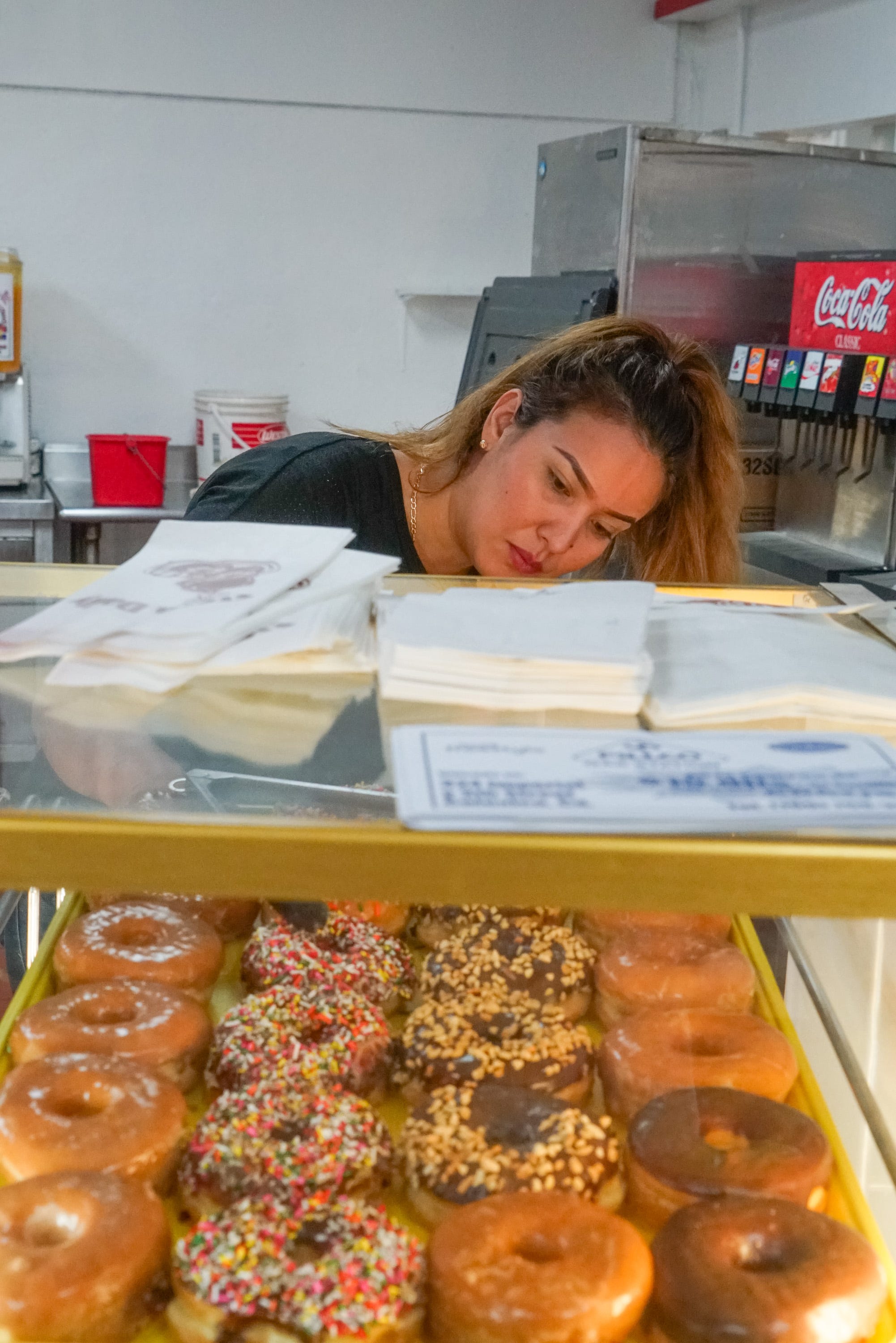 Amalia Vazquez pulls donuts from a tray at Donut Avenue, Calexico, Calif., 12:50 AM, June 12, 2019.