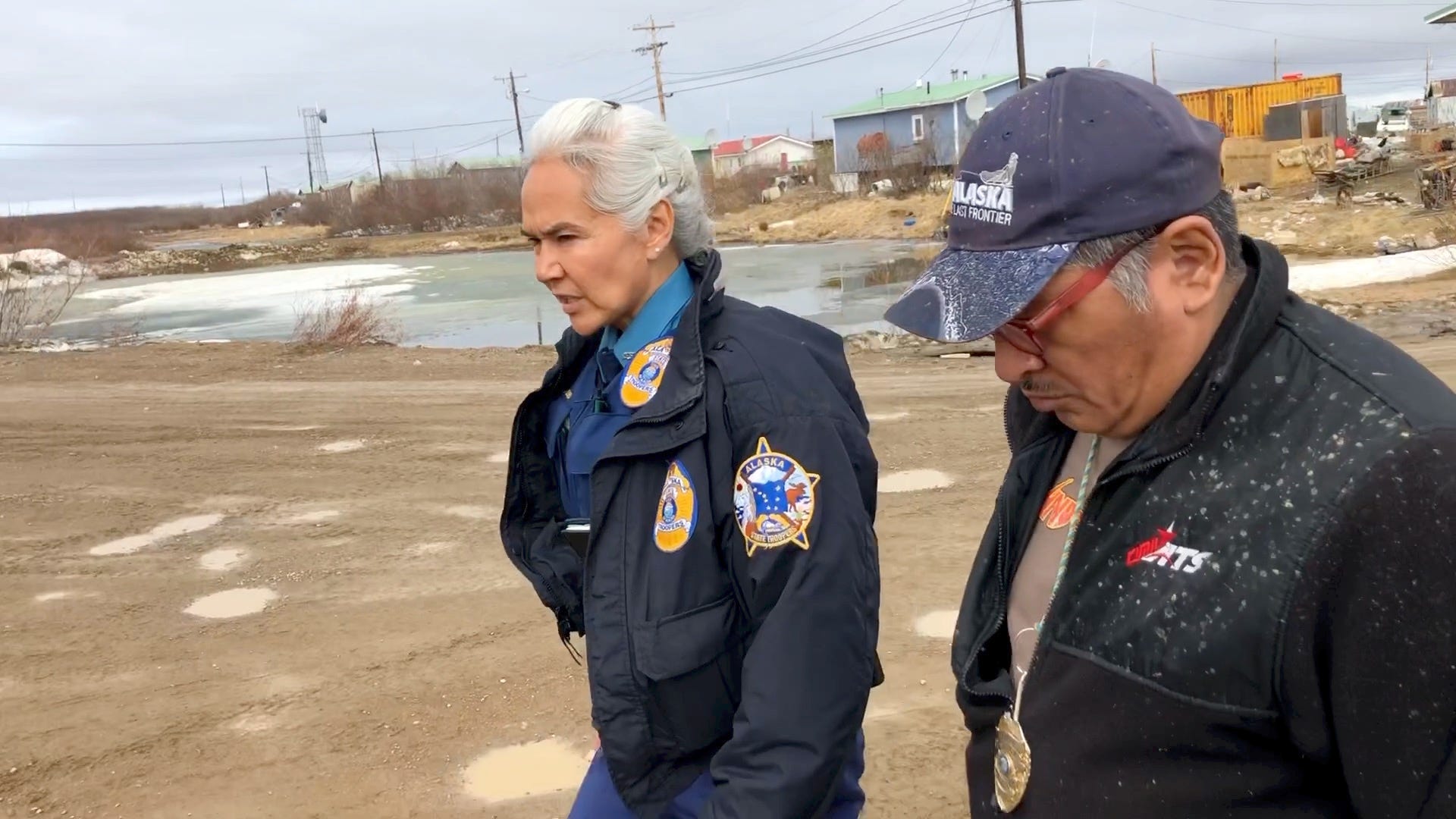 Alaska State Trooper Anne Sears, who is based in Kotzebue, walks through Buckland village with Calvin Brown, one of two Village Police Officers who help keep the peace when troopers aren't there.