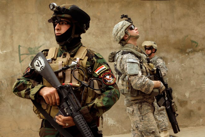 In this March 13, 2009 file photo, an Iraqi Army soldier, left, and U.S. Army soldiers, including Cpl. Jason G. Pautsch, center, from D Co., 1st Combined Arms Battalion, 67th Armor Regiment, stand guard during a joint patrol in Mosul, 360 kilometers (225 miles) northwest of Baghdad, Iraq. Cpl. Pautsch, 20, from Davenport, Iowa, was one of five soldiers killed by a truck bomb on April 10, 2009.
