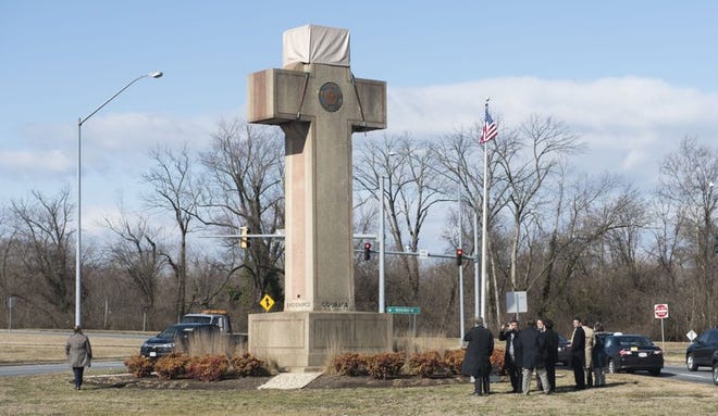 FILE - In this Feb. 13, 2019 file photo, visitors walk around the 40-foot Maryland Peace Cross dedicated to World War I soldiers in Bladensburg, Md. The Supreme Court says the World War I memorial in the shape of a 40-foot-tall cross can continue to stand on public land in Maryland. The high court on Thursday rejected a challenge to the nearly 100-year-old memorial. The justices ruled that its presence on public land doesn’t violate the First Amendment’s establishment clause. That clause prohibits the government from favoring one religion over others.(Photo by Kevin Wolf)