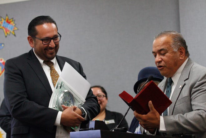 Former Oxnard School District Superintendent Cesar Morales receives a gift from the district school board, presented by personnel commissioner Edward Castillo. Morales currently serves as deputy superintendent of Ventura County Office of Education.