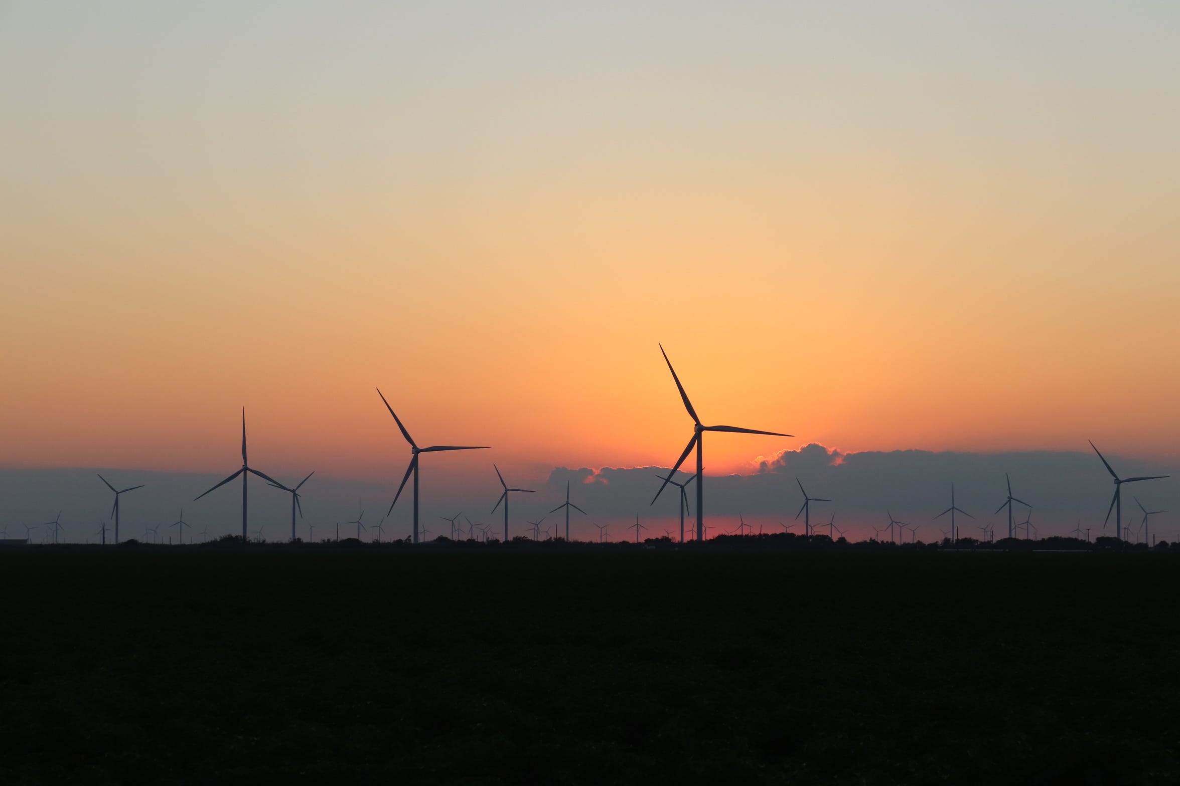 Wind turbines spin at sunset in South Texas.