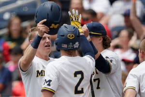 Michigan's Jimmy Kerr, left, is greeted by Jack Blomgren (2) and Jesse Franklin (7) at the dugout after scoring against Texas Tech on Friday.