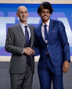 NBA Commissioner Adam Silver, left, poses for photographs with Michigan's Jordan Poole after the Golden State Warriors selected him as the 28th pick overall Thursday.