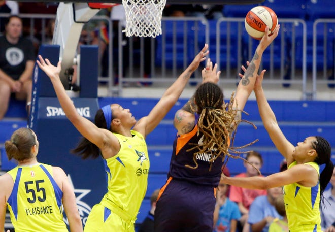 Phoenix Mercury center Brittney Griner (42) shoots between Dallas Wings center Imani McGee-Stafford, left, and Allisha Gray, right, during the first half of a WNBA basketball game Thursday, June 20, 2019, in Arlington, Texas. At left is Wings forward Theresa Pleasance (55). (Steve Hamm/The Dallas Morning News via AP)