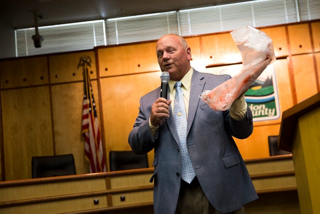 Commisioner Sam Brentano holds a fish during a retirement party for Marion County Chief Administrative Officer John Lattimer at Courthouse Square in Salem on June 20, 2019.