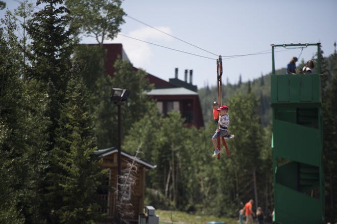 Visitors ride a zip line during a summertime event at Brian Head on Saturday, July 28, 2018. The area has been put under an order to boil drinking water after health officials located E. coli bacteria in the water supply.