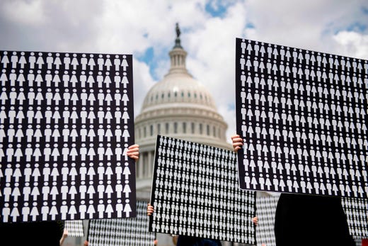 TOPSHOT - Demonstrators hold up placards representing the number of the people who have died due to gun violence on Capitol Hill in Washington, DC, on June 20, 2019, during an event with gun violence prevention advocates. - The group was"remembering the estimated 11,400 people who have died since the US House of Representatives passed bipartisan universal background checks legislation 114 days ago" and urged Senate Majority Leader McConnell to bring the legislation up for a vote. (Photo by Jim WATSON / AFP)JIM WATSON/AFP/Getty Images ORIG FILE ID: AFP_1HO9ZT