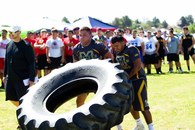 Mayfield High School teammates (L), Juan Castillo, 16, and Omar Munoz, 17 participate in the tire flip. Doug Martin's Football Camp was held at New Mexico State University over the weekend.