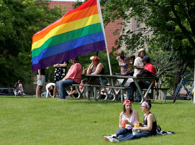 Beth and Andrea Braun, right, sit on the grass at Fountain Park during Sheboygan Pride Picnic, Saturday, June 22, 2019, in Sheboygan, Wis.
