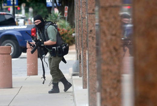 An armed shooter stands near the Earle Cabell Federal Building, June 17, 2019, in downtown Dallas. The shooter was hit and injured in an exchange of gunfire with federal officers outside the courthouse. 