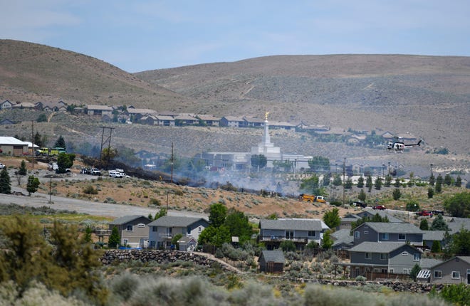 Smoke is seen billowing from a hillside near the Reno Nevada Temple in northwest Reno on June 25, 2019.