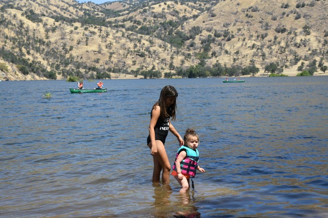 Nicole Brasher, 1, and Ambrielle Hernandez wade into a nearly-full Lake Kaweah on June  24, 2019.