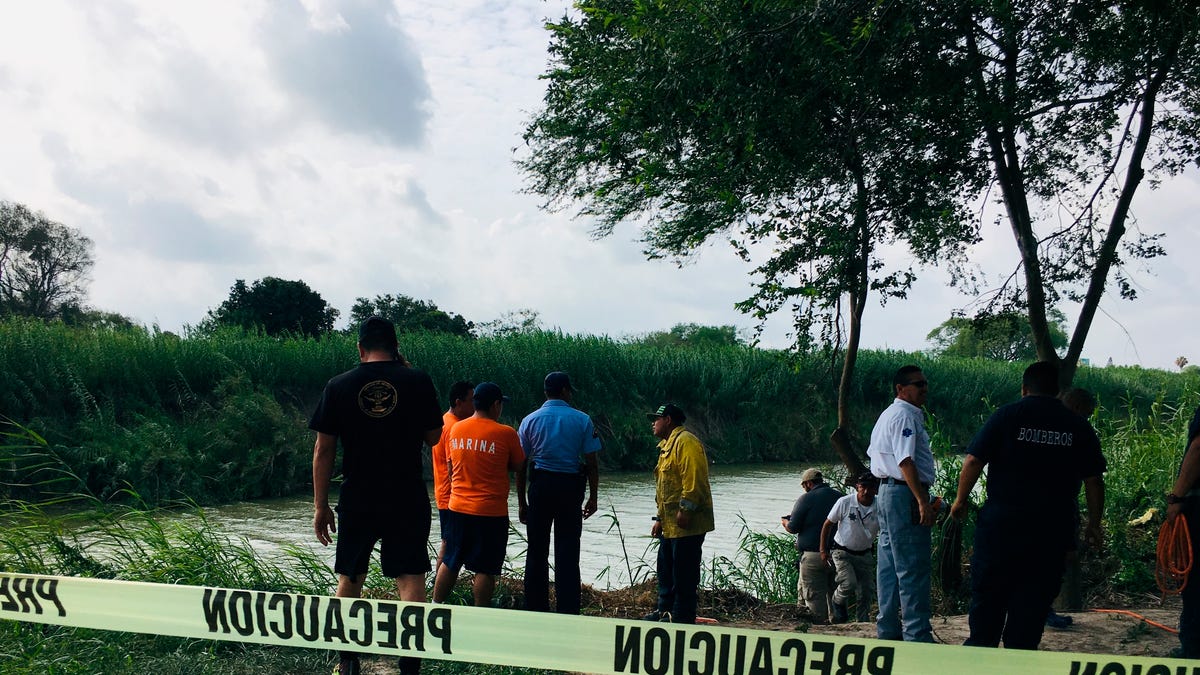 Authorities stand behind yellow warning tape along the Rio Grande bank where the bodies of Salvadoran migrant Oscar Alberto Martínez Ramírez and his nearly 2-year-old daughter Valeria were found, in Matamoros, Mexico, Monday, June 24, 2019, after they drowned trying to cross the river to Brownsville, Texas. Martinez' wife, Tania told Mexican authorities she watched her husband and child disappear in the strong current. (AP Photo/Julia Le Duc)   ORG XMIT: MEX105