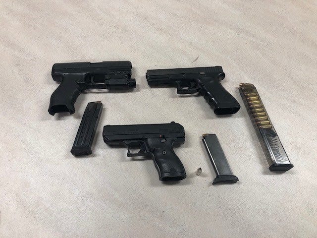Three handguns, including two that were loaded, were located in a Kia stopped Tuesday night for going 100 miles per hour on Interstate 70.