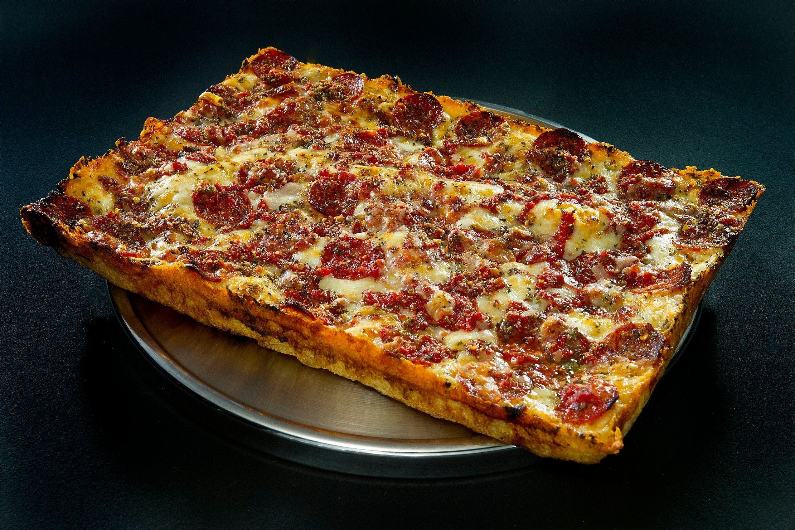 Detroit-style pizza from Buddy's Pizza, thick, square, crispy, tangy.