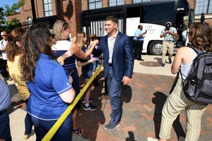 Erik Bakich is greeted as the Michigan baseball team arrives at Fisher Stadium on Thursday.