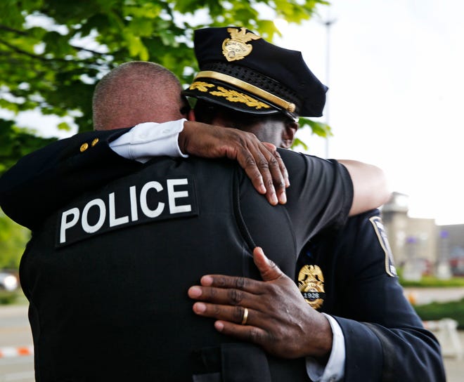 Racine Police Chief Art Howell, (facing camera) embraces another officer following a news conference Thursday to announce an arrest in the fatal shooting of Racine Police Officer John Hetland.