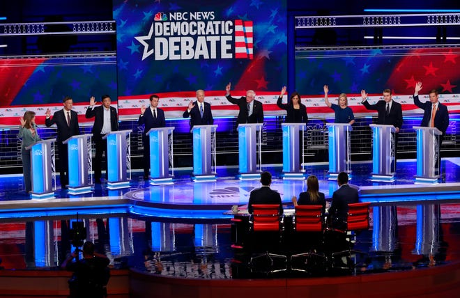 Democratic presidential candidates, author Marianne Williamson, former Colorado Gov. John Hickenlooper, entrepreneur Andrew Yang, South Bend Mayor Pete Buttigieg, former Vice President Joe Biden, Sen. Bernie Sanders, I-Vt., Sen. Kamala Harris, D-Calif., Sen. Kirsten Gillibrand, D-N.Y., former Colorado Sen. Michael Bennet, and Rep. Eric Swalwell, D-Calif., raise their hands when asked if they would provide healthcare for undocumented immigrants, during the Democratic primary debate hosted by NBC News at the Adrienne Arsht Center for the Performing Arts, Thursday, June 27, 2019, in Miami.