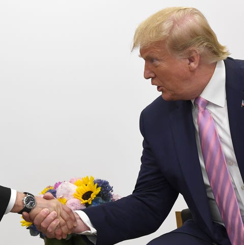 President Donald Trump shakes hands with Russian...