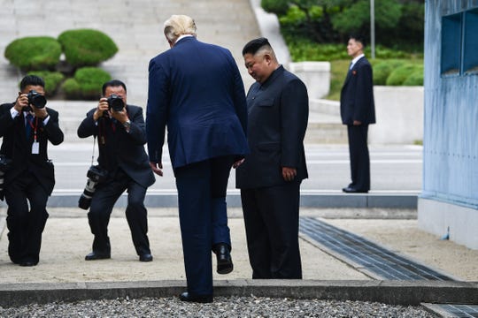 President Donald Trump steps into the northern side of the Military Demarcation Line that divides North and South Korea, as North Korea's leader Kim Jong Un looks on during their meeting in the Demilitarized zone (DMZ) on Sunday, June 30, 2019.