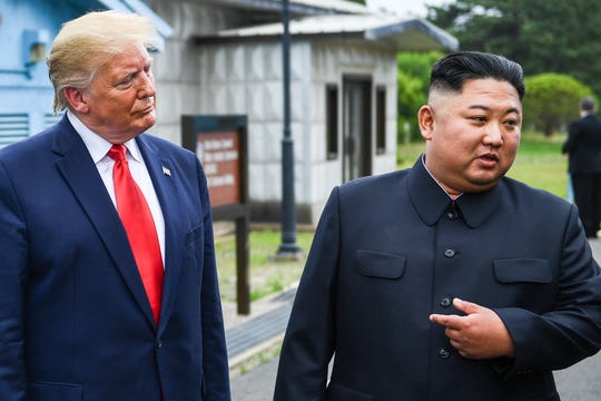 North Korea's leader Kim Jong Un (right) speaks as he stands with President Donald Trump at the Demilitarized zone (DMZ) between North and South Korea on Sunday, June 30, 2019.