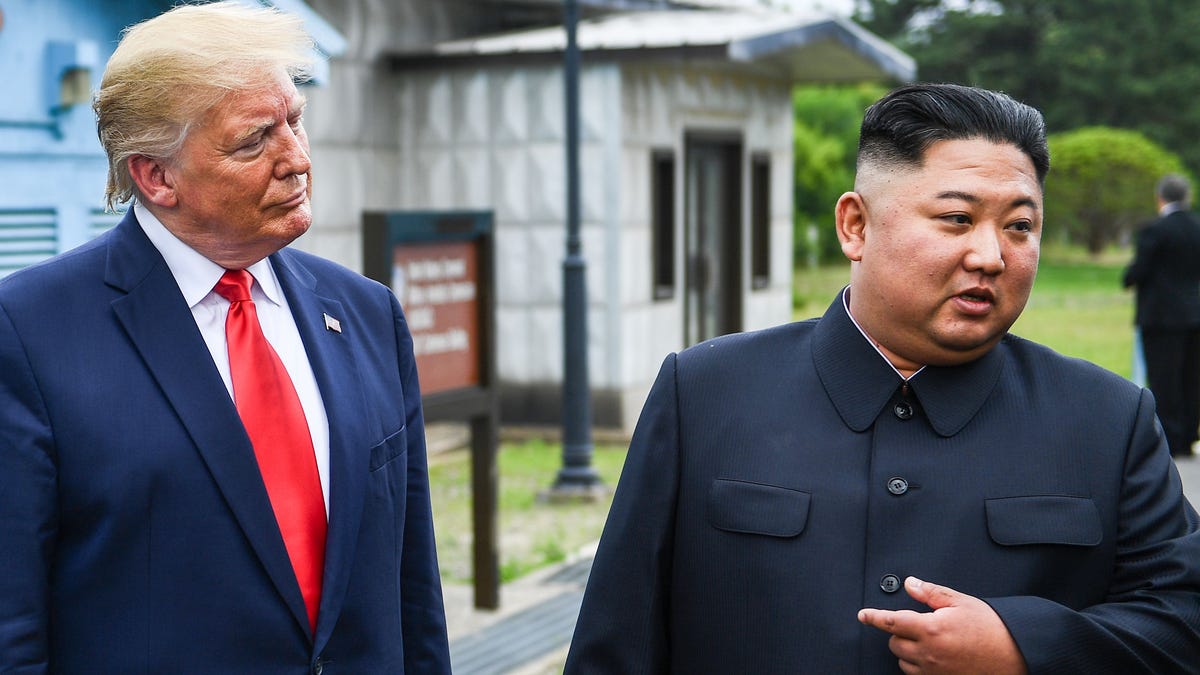 North Korea's leader Kim Jong Un (right) speaks as he stands with President Donald Trump at the Demilitarized zone (DMZ) between North and South Korea on Sunday, June 30, 2019.